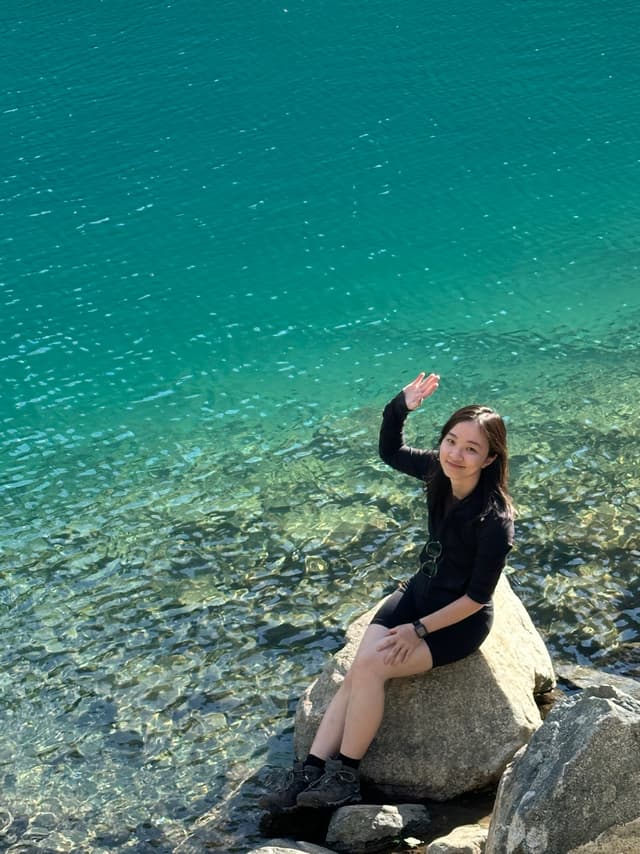 Gina waving by the lake